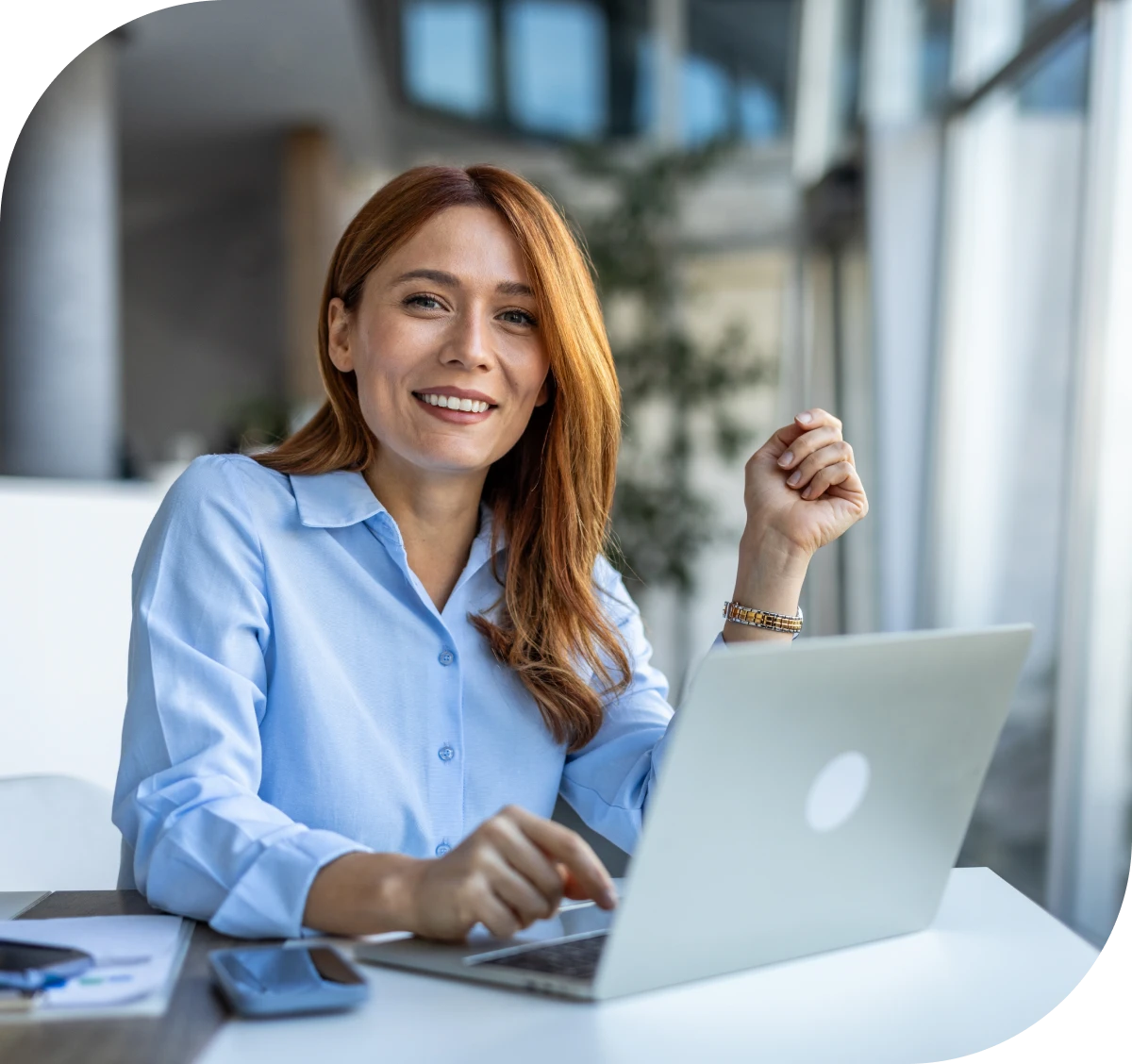 Woman smiling while working on a laptop.