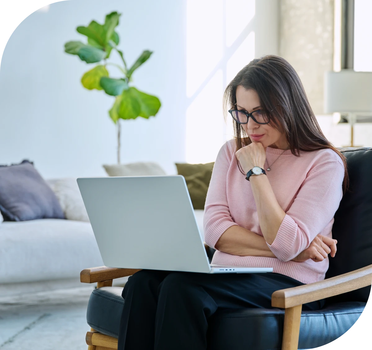 Woman working on laptop in cozy room.